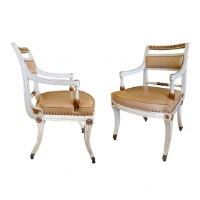 a stylish pair of 1940's hollywood regency ivory-painted and parcel-gilt klismos armChairss