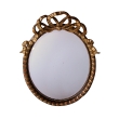a festive and large-scaled napoleon iii ebonized and giltwood oval mirror with a carved ribbon crest