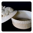 a charming french beige-colored pottery basket-weave bowl with cover adorned with two rabbits