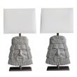 a well-carved and stylized pair of italian romanesque style gray painted wooden masks now mounted as lamps