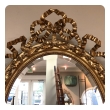 A French Napoleon III Giltwood and Composite Oval Mirror with Ribbon Crest and Oak Leaf Border