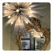 Jean de Merry Sputnik chandelier hanging above ornate gold mirror in room setting