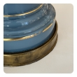 Side view of stepped glass base with gilt bands and patinated brass feet